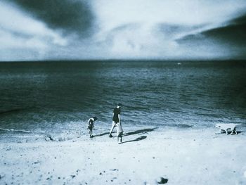 People on beach against sky