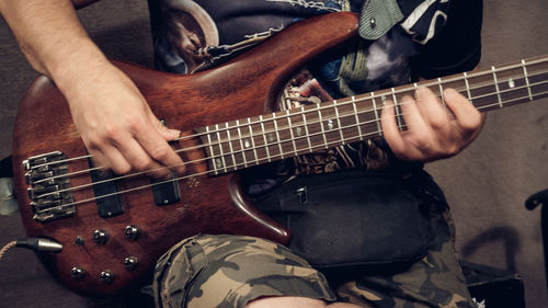 Midsection of man playing guitar