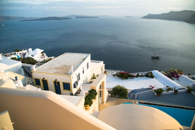 High angle view of houses on mountain by sea against sky