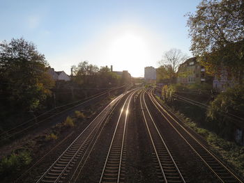Railroad tracks against clear blue sky on sunny day