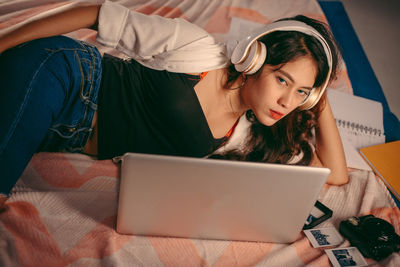 Portrait of young woman using mobile phone at home