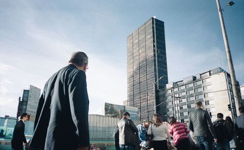 Low angle view of people walking on city street