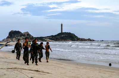 People at beach against sky