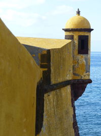 Old church by sea against sky