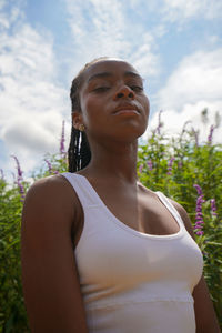 Portrait of young woman standing against trees