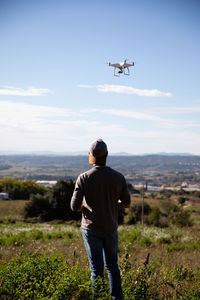 Rear view of man looking at airplane