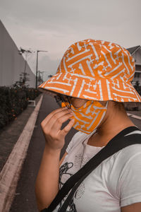 Close-up of southeast asian teenage girl wearing colorful hat and mask 