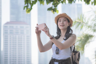 Portrait of young woman using mobile phone outdoors