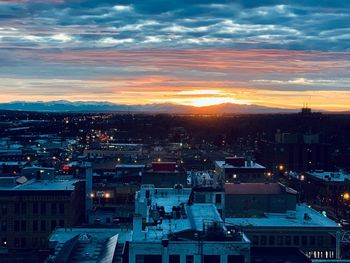 High angle view of illuminated city against sky at sunset