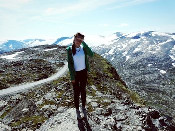 Man standing on snowcapped mountain against sky