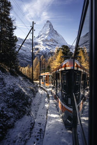 Road amidst snowcapped mountains against sky