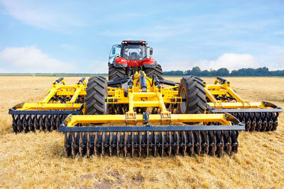 Toothed metal multi-row yellow harrow as a tractor hitch for agricultural processing of fields.