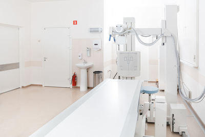 X-ray department in modern hospital. radiology room with scan machine with empty bed.