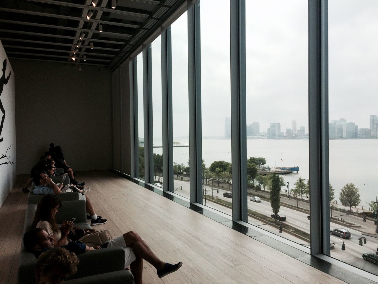 indoors, architecture, built structure, window, glass - material, city, building exterior, transparent, table, day, empty, chair, sunlight, incidental people, sky, absence, railing, modern, bench, building