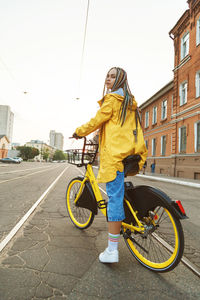Portrait of young woman riding bicycle on street