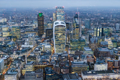 Aerial view of illuminated cityscape during sunset