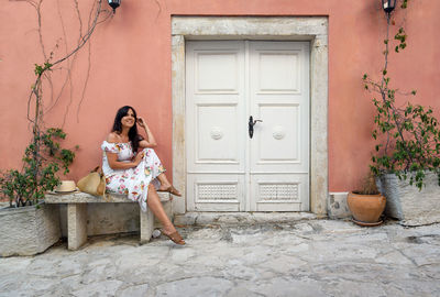 Portrait of woman sitting outside building