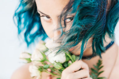 Close-up of woman holding flowers against sky