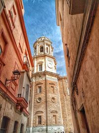 Low angle view of clock tower amidst buildings in city