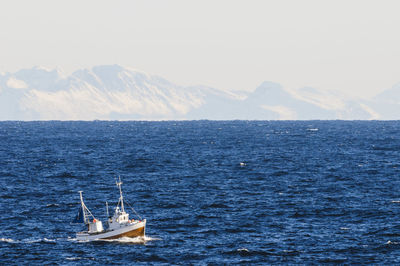 Boat on sea, iceberg on background