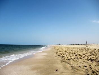 Scenic view of beach against clear blue sky