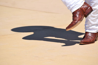 Low section of man dancing on footpath