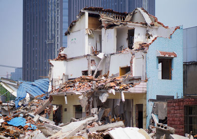 Abandoned houses against sky in city