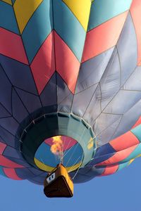 Low angle view of hot air balloon against sky  with flame from basket