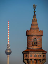 Communications tower in city against clear sky