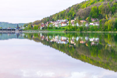 Scenic view of lake by buildings against sky