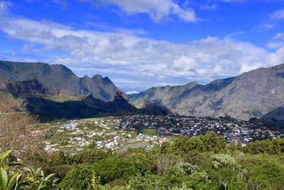 Scenic view of townscape and mountains against sky