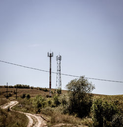 Electricity pylon on field against clear sky