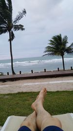 Low section of man relaxing on beach