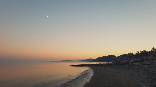 Scenic view of sea against clear sky during sunset