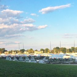 Deck chairs on grass against sky