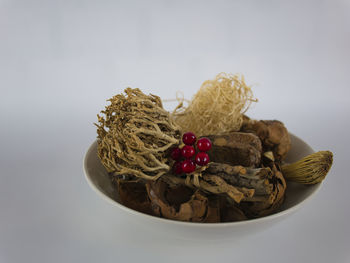 Close-up of fruits in bowl against white background