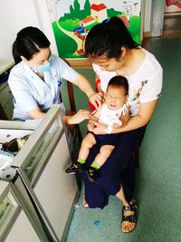 High angle view of mother and daughter sitting on floor