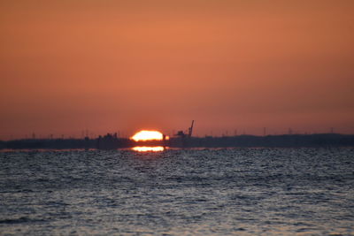 Scenic view of sea against orange sky