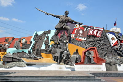 Low angle view of statues against sky