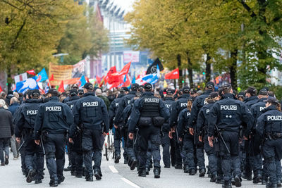 Rear view of police force walking on street