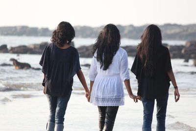 Rear view of women standing in sea