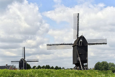 Traditional windmill on field against sky