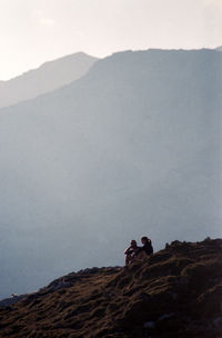 People on mountain against sky