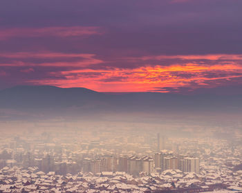 Aerial view of buildings against sky during sunset