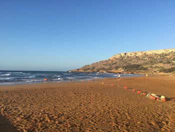 Scenic view of beach against clear blue sky