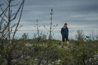 Man walking on land against sky