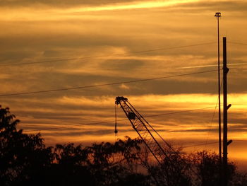 Silhouette communications tower against sky during sunset