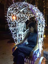 Girl playing with ball sitting at night