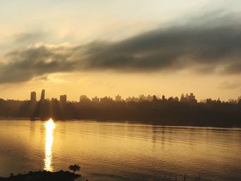 Scenic view of silhouette buildings against sky during sunset