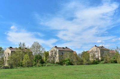 Old house on field against sky